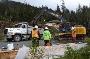 In this file photo from August 2015, In this file photo from August, a team of volunteers works to remove mud, logs and other debris from the site where Christine McGraw's house once stood. McGraw's house was destroyed by the Aug. 18, 2015 landslide that killed three people, two of whom were inside her house painting at the time.