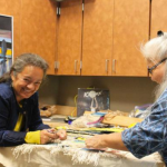In this file photo from August, Clarissa Rizal, left, and Della Cheney, right, work on the "Weavers Across the Water" robe.