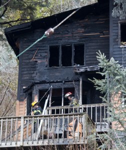 Capital City Fire/Rescue firefighters remove water hoses after responding to a duplex fire at 623 Basin Road on Tuesday, Jan. 31, 2017. The fire originally started before midnight on Monday and reignited about 6:30 Tuesday morning. One person was taken to the hospital and a dog died in the fire. (Michael Penn | Juneau Empire)