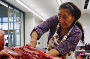 In this Jan. 27 photo, Dena&rsquo;ina elder Helen Dick cuts meat from a moose head in the demonstration kitchen of the Dena&rsquo;ina Wellness Center in Kenai, Alaska. Dick, who also helps teach a Dena&rsquo;ina language class at Kenai Peninsula College, came to the Wellness Center to demonstrate the techniques of butchering and preparing moose head that she learned in her childhood. (Ben Boettger | Peninsula Clarion)