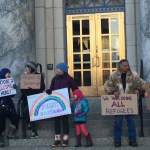 People gathered prior to work (from 7-8:30 a.m.) Monday in front of the Alaska State Capitol to support refugees and immigrants. (Mary Catharine Martin | Juneau Empire)