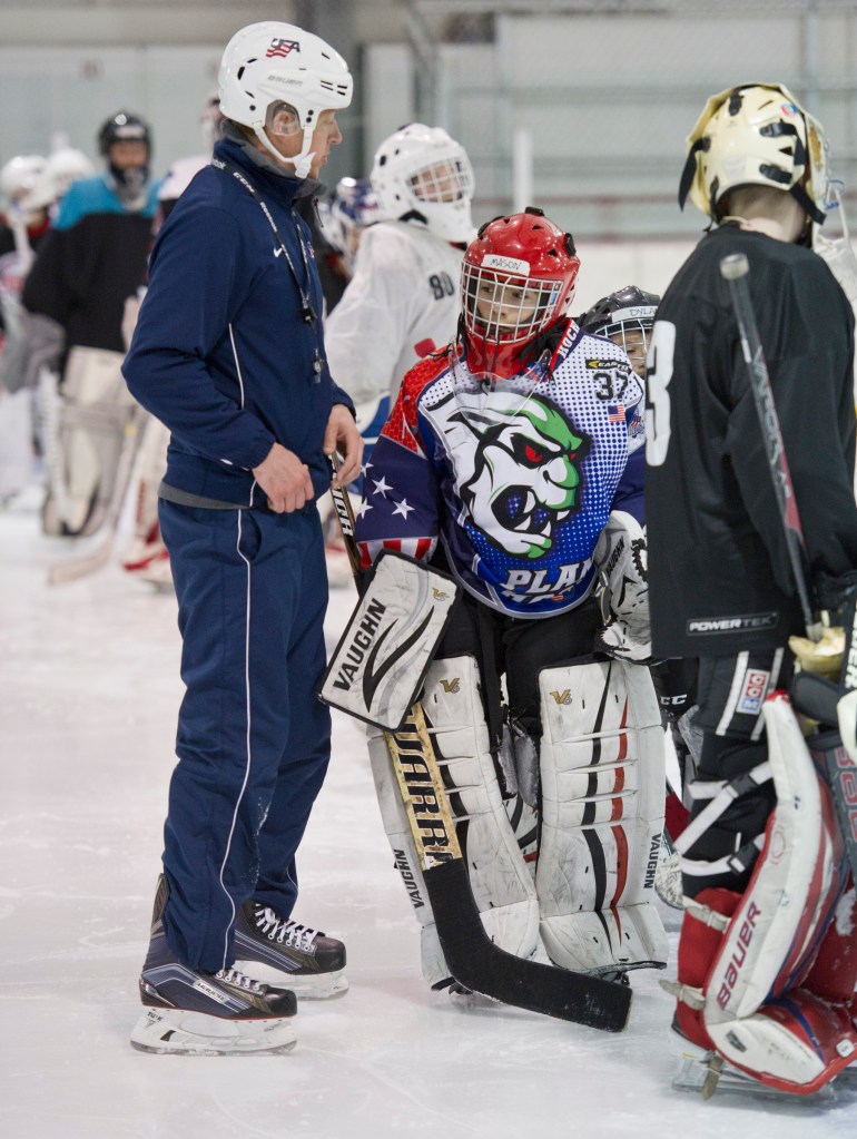 Mason Sooter, right, gets attention from Wylie Rogers, of Elite Goaltending, during a goaltending workshop at Treadwell Arena on Wednesday. (Michael Penn | Juneau Empire)