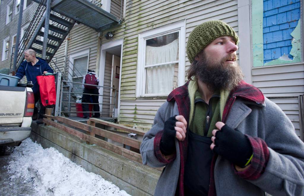 Travis Johnson waits outside the Bergmann Hotel as friends pack up their belongings after the city closed the hotel for health and safety reasons on Friday. Johnson said he had been staying at the hotel and helping out as a day laborer. (Michael Penn | Juneau Empire)