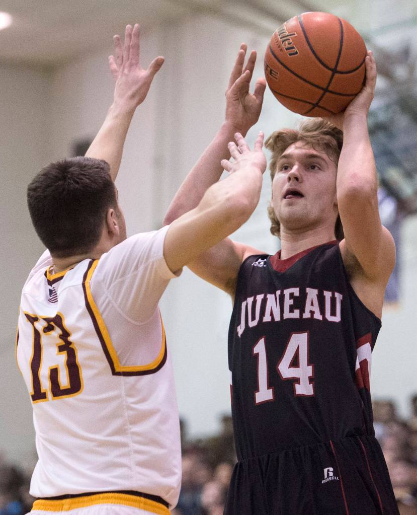 Juneau-Douglas&rsquo; Kasey Watts shoots against Ketchikan&rsquo;s Jake Smith during the Region V Basketball finals at JDHS on Friday. (Michael Penn | Juneau Empire)