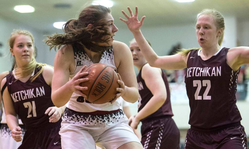 Juneau-Douglas&rsquo; Cassie Dzinich gathers a loose ball against Ketchikan&rsquo;s Ashley Hoffine, left, and Hannah Maxwell during the Region V Basketball finals at JDHS on Friday. Ketchikan won 41-39 to force a playoff game on Saturday. (Michael Penn | Juneau Empire)