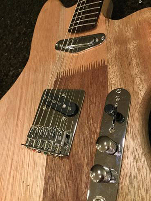 This guitar created by luthier George Gress was built to match the decor of Amalga Distillery. It&rsquo;s made from the same Boeing Airlines mahogany shipping crates that are throughout the distillery, he said. Photo courtesy of George Gress.