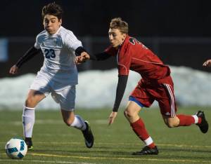 Thunder Mountain&rsquo;s Franco Vidal, left, races Juneau-Douglas&rsquo; Aidan Hopson to the ball during their first match of the season at TMHS on Friday, March 31, 2017. (Michael Penn | Juneau Empire)