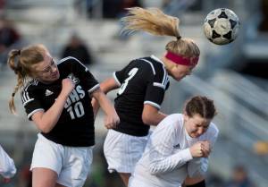 Juneau-Douglas&rsquo; Erika Holst, left, and Michaela Bentley attempt to score off a corner kick against Thunder Mountain&rsquo;s Meghan Penrose during their match at TMHS on Tuesday, April 11, 2017. Juneau-Douglas won 1-0. (Michael Penn | Juneau Empire)