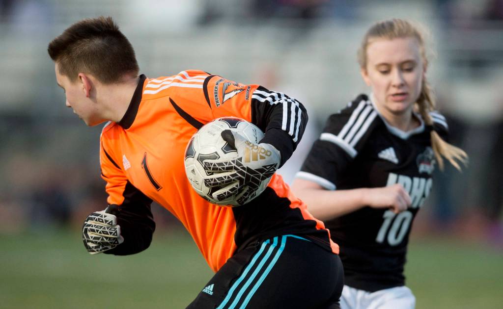 Thunder Mountain&rsquo;s goalie Lannea Sutak hides the ball from Juneau-Douglas&rsquo; Erika Holst at TMHS on Tuesday, April 11, 2017. Juneau-Douglas won 1-0. (Michael Penn | Juneau Empire)