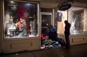 Chloe Abbott checks in with a homeless person camping in a business doorway on South Franklin Street on March 25, 2017. (Michael Penn | Juneau Empire)
