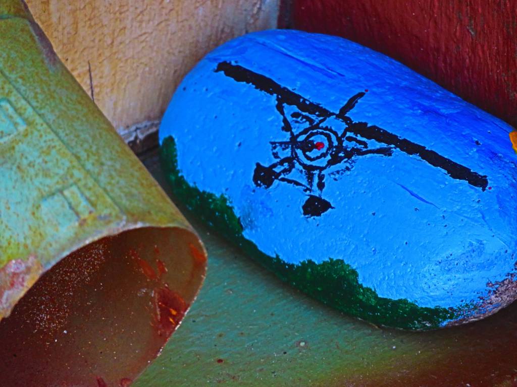 Painted rock &lsquo;hidden&rsquo; near a roof gutter drainage pipe. Photo by Ray Tsang.