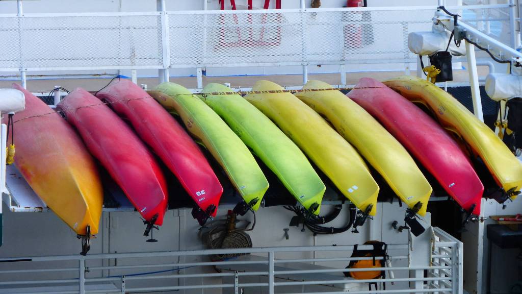 A rainbow of kayaks waiting for summer fun. Photo by Denise Carroll.