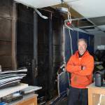 Art Sutch examines the damage in his photography shop on Seward Street on Monday, April 17, 2017, after a fire started on the outside wall Saturday evening caused about $30,000 damage.