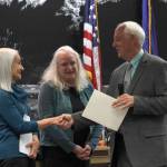 Mayor Ken Koelsch officially declares April 20-July 4 as Douglas Days at an April 3 City and Borough of Juneau Assembly meeting. Douglas residents Paulette Simpson (left) and Mary Kay Pusich, two of the organizers of Douglas Days, were there for the meeting. (Alex McCarthy | Juneau Empire)