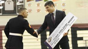US Marine Sgt. James White congratulates Cody Weldon, 18, with the Naval Reserve Officer Training Corps scholarship Tuesday, April 18, at Juneau-Douglas High School. Weldon was one of two Alaskan high school students to be given the scholarship. (Photo by Alex McCarthy)