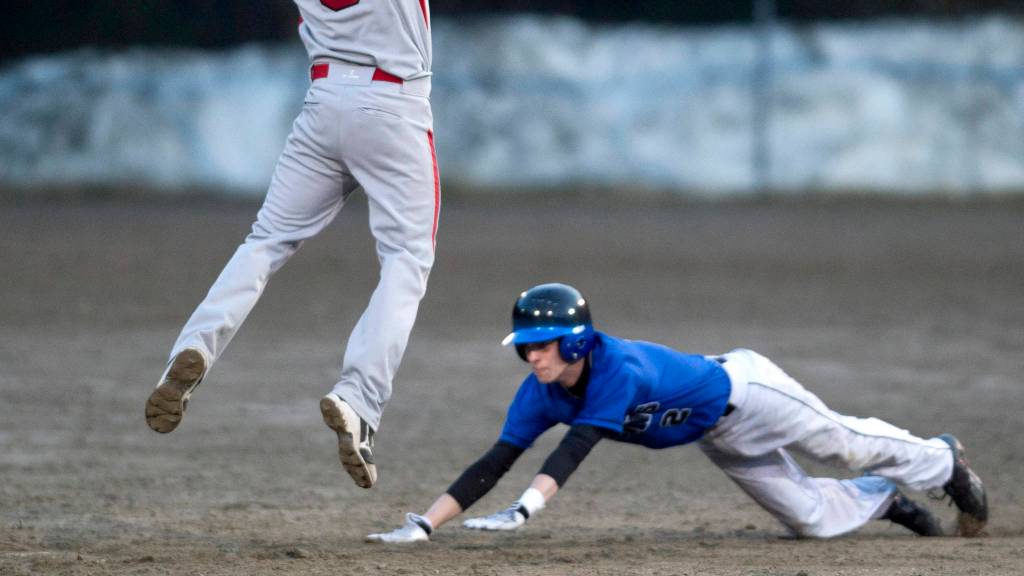 Juneau-Douglas&rsquo; Luke Mallinger misses a catch that allows Thunder Mountain&rsquo;s Sammy McKnight to get back to first base safely at Adair-Kennedy Memorial Park on Friday, April 21, 2017. McKnight moves onto third base on the second inning play. (Michael Penn | Juneau Empire)