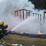 Capital City Fire/Rescue personnel fire a fire that consumes the playground at Twin Lakes on Monday, April 24, 2017. (Michael Penn | Juneau Empire)
