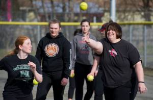 Juneau-Douglas High School girls varsity softball head coach Lexie Razor throws a ball for freshman Kamper Hart during a warmup drill during practice at Melvin Park on Tuesday, April 25, 2017. JDHS plays Ketchikan this weekend. (Michael Penn | Juneau Empire)