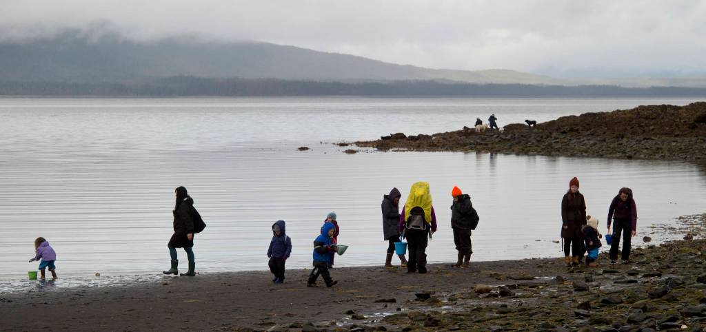 Parents and their children explore the beach during the lowest tide of the month, -4.2 feet, on Douglas Island near Shaman Island on Friday, April 28, 2017. (Michael Penn | Juneau Empire)
