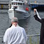Michael Grubbs, a volunteer &ldquo;verger&rdquo; with the Holy Trinity Episcopal Church, whips holy water toward the F/V Patriot as part of the Blessing of the Fleet on Saturday, May 6.