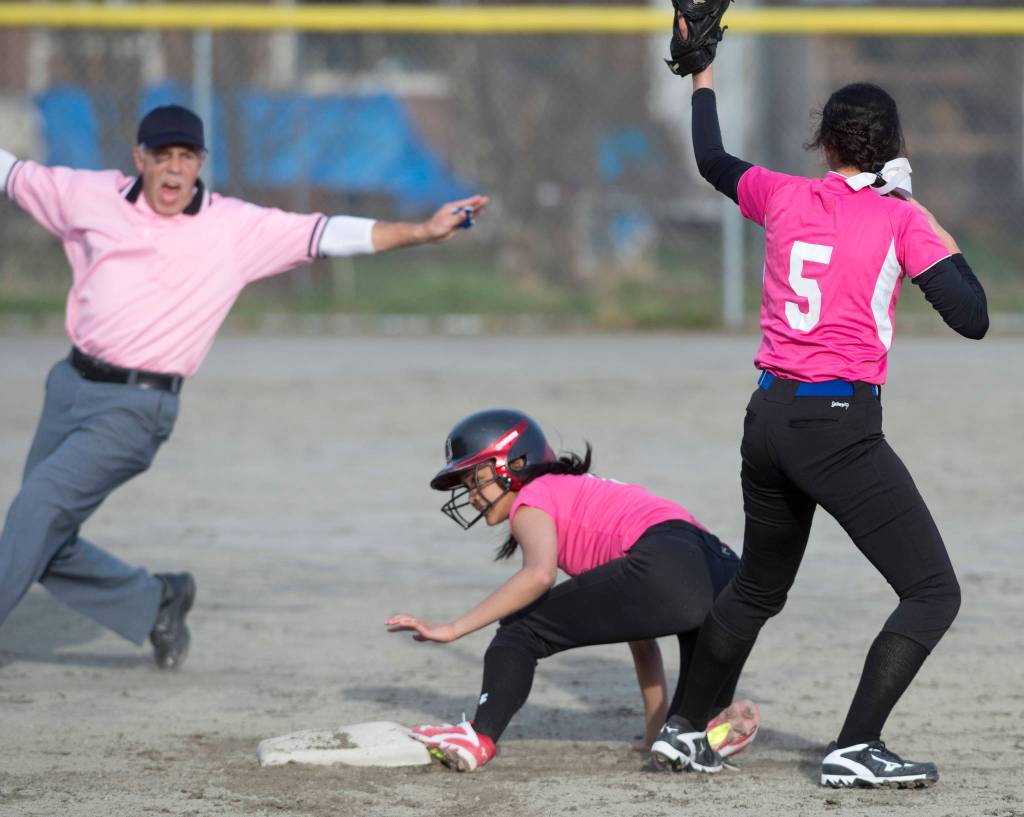 Field referee Everett Boster calls Juneau-Douglas&rsquo; Alyxn Bohulano safe at second under the tag by Thunder Mountain&rsquo;s Maxie Saceda-Hurt in the first inning at Melvin Park on Friday. (Michael Penn | Juneau Empire)