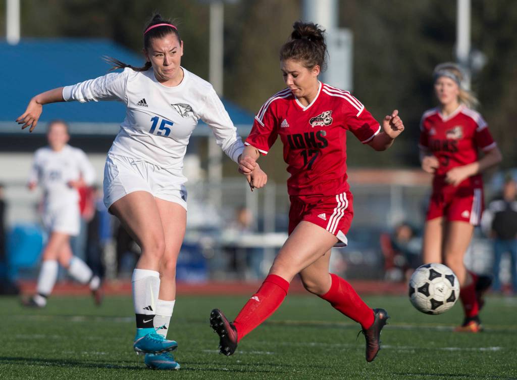 Thunder Mountain&rsquo;s Anne Coogan, left, kicks the ball away from Juneau-Douglas&rsquo; Brianna Jokerst at TMHS on Tuesday, May 9, 2017. (Michael Penn | Juneau Empire)