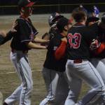 Teammates celebrate Bryan Miramontes&rsquo; game-winning tag up from third base in the eighth inning Friday at Adair-Kennedy. (Nolin Ainsworth | Juneau Empire)