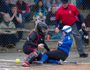 MICHAEL PENN | JUNEAU EMPIRE Thunder Mountain&rsquo;s Rachel Macaulay, right, slides safely home as the ball gets away from Juneau-Douglas&rsquo; catcher Morgan Balovich during their game at Melvin Park on Friday.