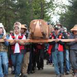 Tribal members carry the Raven Totem Pole to its site flanking the Huna Tribal House. (Mary Beth Moss | For the Capital City Weekly)