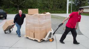 Brad Folckomer, perishable foods manager for Foodland IGA, left, and cashier Brian Lauth deliver 29 boxes of food for the store&rsquo;s 3 Square Program to Riverbend Elementary School on Wednesday, May 24, 2017. (Michael Penn | Juneau Empire)