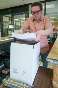 Will Muldoon, a data processing technician for the state of Alaska, boxes printed pink slip letters at a printing facility in the State Office Building on Tuesday, May 30, 2017. The letters will be sent to state employees on Thursday, June 1, if the legislature fails to pass a budget by then. (Michael Penn | Juneau Empire)