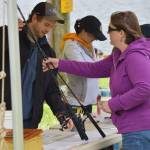 An Alaska Department of Fish & Game worker checks out fishing gear on Family Fishing Day at Twin Lakes on Satruday, June 3, 2017. (Kevin Gullufsen | Juneau Empire)