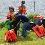 The U.S. Forest Service&rsquo;s Barbara J. Adams outfits a boy with a lifejacket at Family Fishing Day at Twin Lakes on Saturday, June 3. (Kevin Gullufsen | Juneau Empire)