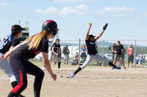 Kyra Jenkins Hayes winds up for the pitch while Juneau-Douglas High School&rsquo;s Elisa Fabrello waits attentively at third base during the ASAA Small Schools State Championship game, Saturday, June 3. (Sarah Manriquez | For the Juneau Empire)