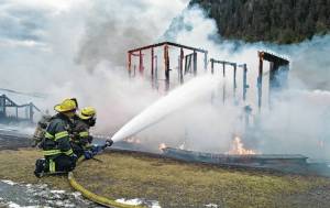 Capital City Fire/Rescue personnel fire a fire that consumes the playground at Twin Lakes on Monday, April 24, 2017. (Michael Penn | Juneau Empire)