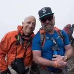 Juneau man Terry White (right) poses with fellow climber Gary Rudman as they trek up Mt. Kilimanjaro. The group climbed the mountain this February, and is already talking about a reunion. (Photo courtesy of John Waller, Uncage the Soul Productions)