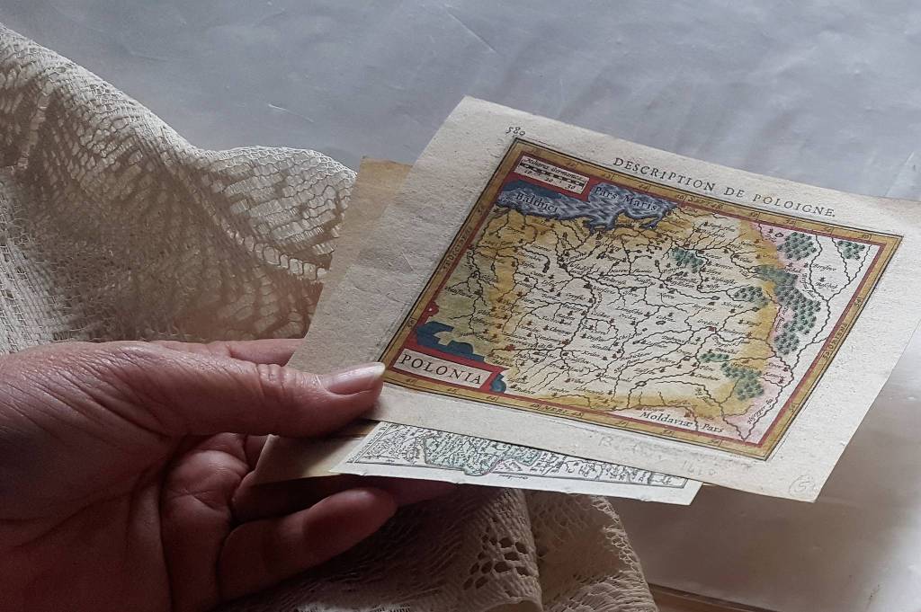 Patti David holds several 17th-century maps at The Observatory bookstore as she helps the family dispose of the stock after more than three decades in business. (Liz Kellar | Juneau Empire)