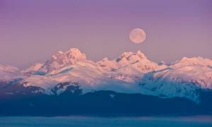 A full moon sets over the Chilkat Mountain Range on the west side of Lynn Canal. (Michael Penn | Juneau Empire file)