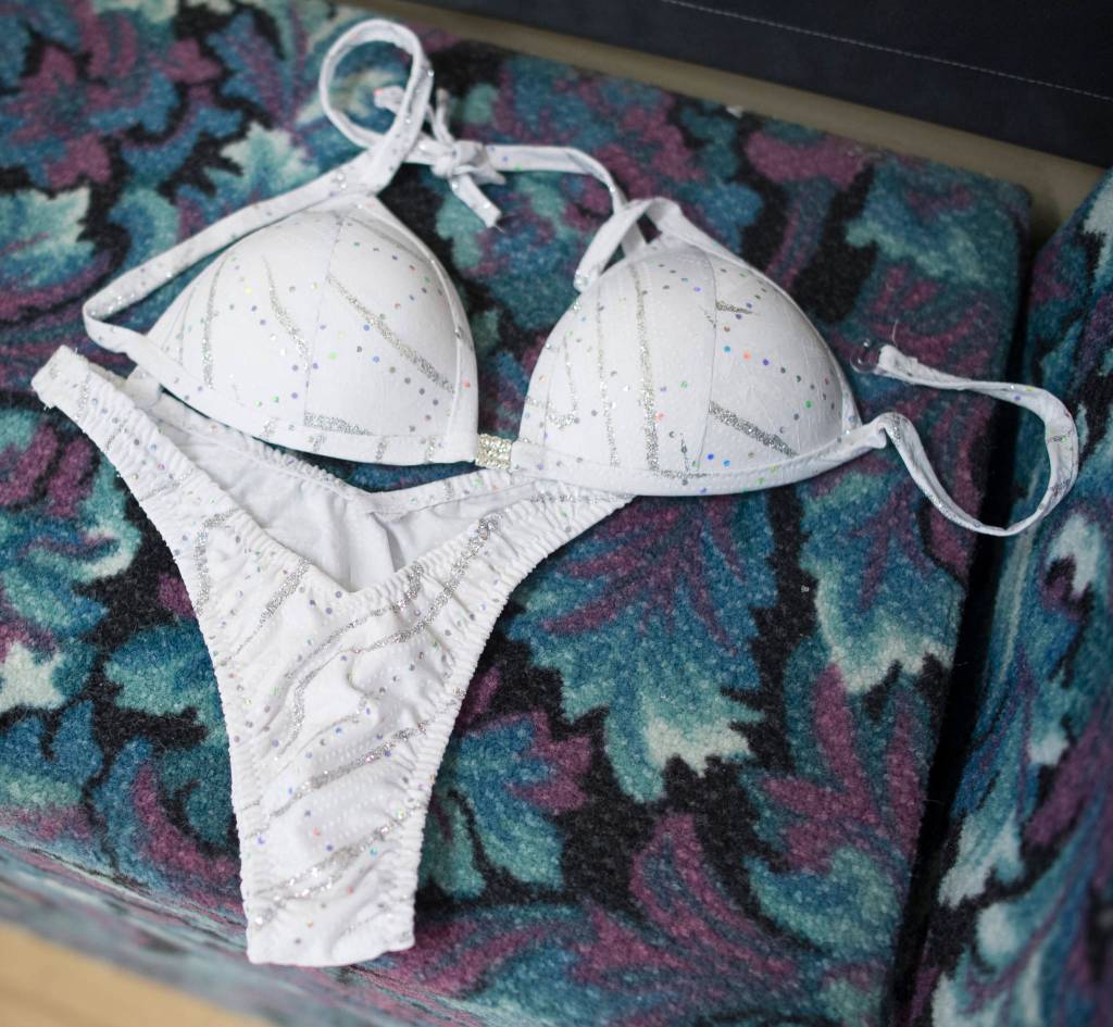 Lacey Godkin lays out her posing suit at the downtown Alaska Club on Wednesday, June 21, 2017, before her trip to Anchorage to compete in her first figure contest. (Michael Penn | Juneau Empire)