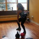 Kristin Mabry, owner and instructor at Mountainside Wellness, demonstrates a kettlebell exercise to her class Monday afternoon. (Erin Granger | Juneau Empire)