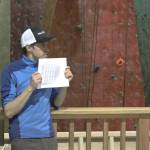 Rock Dump Gym board member Eran Hood holds up a copy of the climbing gym&rsquo;s budget at a community meeting Tuesday. The gym signed an 18-month extension to its lease in order to stay in its current spot near the Alaska-Juneau Dock. (Alex McCarthy | Juneau Empire)