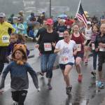 Runners parade through downtown in the Glenn Frick Memorial Mile just 30 minutes before the start of the Fourth of July parade. (Nolin Ainsworth | Juneau Empire)