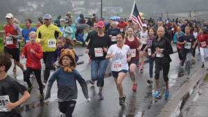 Runners parade through downtown in the Glenn Frick Memorial Mile just 30 minutes before the start of the Fourth of July parade. (Nolin Ainsworth | Juneau Empire)