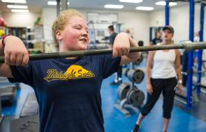 Mia Loree lifts weights under the guidance of Cori Metzger, Director of Sports Performance at Western Oregon University and host of the Juneau Football and Sports Performance Camp, at the Thunder Mountain High School on Tuesday, July 11, 2017. (Michael Penn | Juneau Empire)
