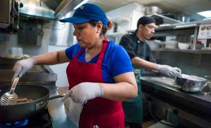 Julia Felix cooks with her son, Cesar Bellido, on Thursday, July 13, 2017, at their new Peruvian restaurant called Four Plates in the Frontier Suites Airport Hotel. (Michael Penn | Juneau Empire)