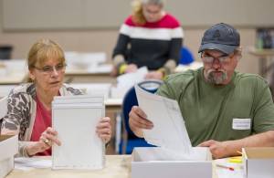 In this August 2016 photo, hand count team members Christine Niemi, left, and James Fowlkes count ballots at Centennial Hall from the state-wide primary election. (Michael Penn | Juneau Empire File)