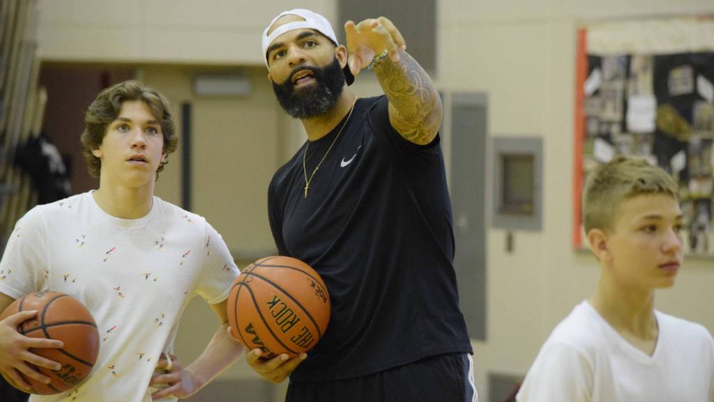 Carlos Boozer talks with incoming Juneau-Douglas High School freshman Cooper Kriegmont Wednesday at camp. (Nolin Ainsworth | Juneau Empire)