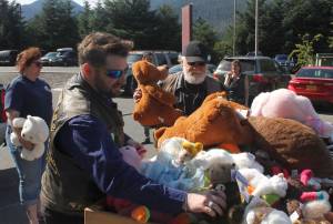 PHOTOS BY ALEX McCARTHY | JUNEAU EMPIRE Justin Papenbrock, a sergeant-at-arms for the Southeast Alaska Panhandlers Motorcycle Club, places a stuffed animal on a pile of donated toys on Thursday. The club brought 10 large trash bags of stuffed animals, raised at the 23rd annual Toy Run, to Bartlett Regional Hospital.
