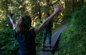 Tory Houser, left, and Dee Galla, of the U.S. Forest Service, persaude a brown bear to move off the trail at the Anan Creek Wildlife Observatory on Wednesday, August 9, 2017. (Michael Penn | Juneau Empire)