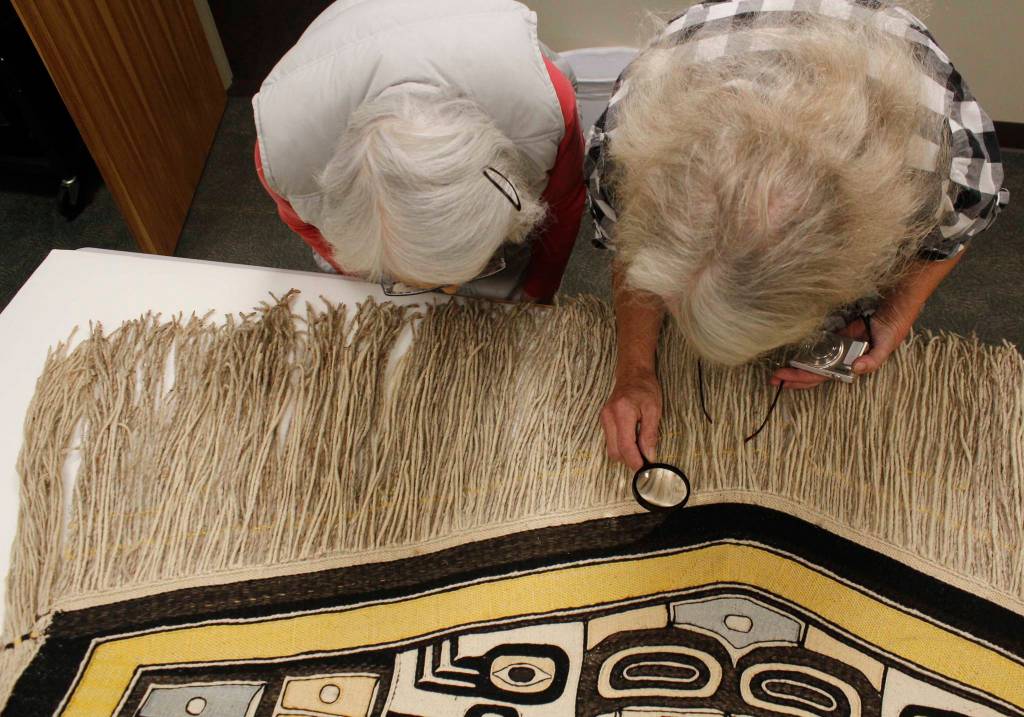 Weavers Delores Churchill (left) and Kay Field Parker examine a Chilkat robe that was donated to Sealaska Heritage Institute. The robe is estimated to be from the late 1800s or late 1900s and is expected to be an important teaching tool for weavers. (Alex McCarthy | Juneau Empire)